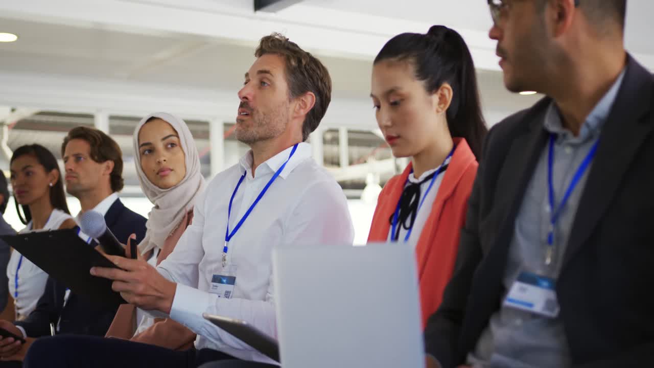 비즈니스 컨퍼런스 에서 남성 관객 이 질문 을 하고 있다