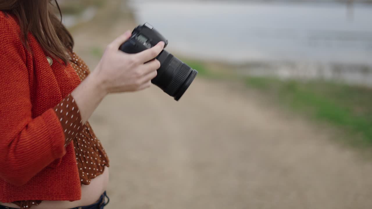 Woman with Camera by the Riverbank