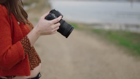 woman with camera by the riverbank