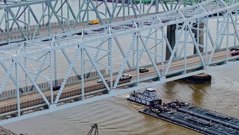 aerial view of barge cruising in mississippi river under the crescent city connection bridge in new orleans, louisiana, usa
