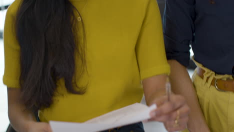 tracking in from busy office table to woman talking to colleagues