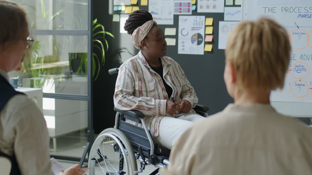 Female Business Coach in Wheelchair Giving Corporate Training