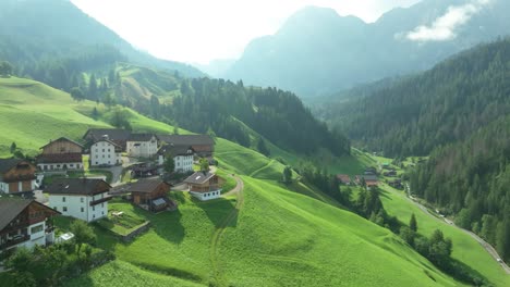 imágenes aéreas cinematográficas de las pintorescas granjas en las exuberantes colinas verdes del pueblo de la val en los dolomitas italianos