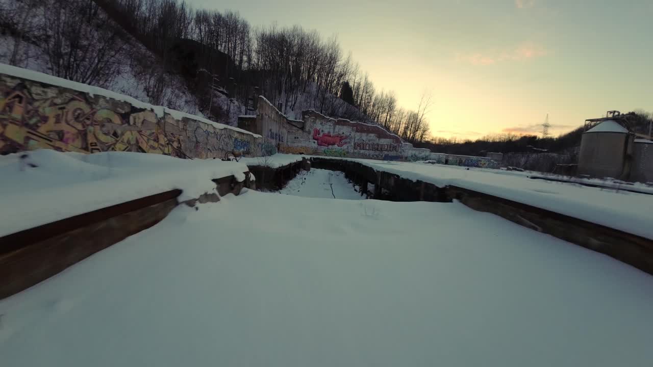 Belgo Factory Shawinigan, Quebec, Canada: volo con drone FPV lungo un ponte innevato con graffiti, edifici industriali abbandonati durante la stagione invernale
