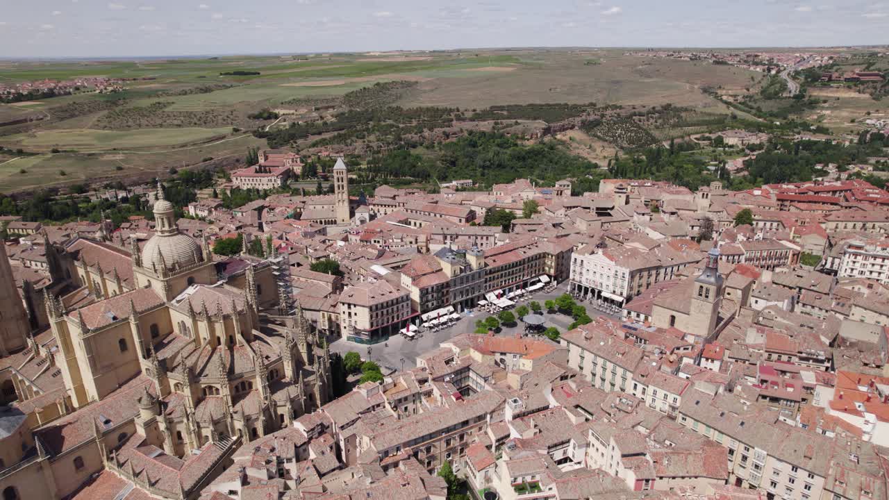 vista aérea sobre la plaza mayor junto a la catedral de segovia en un día soleado con campos rurales en el fondo lejano