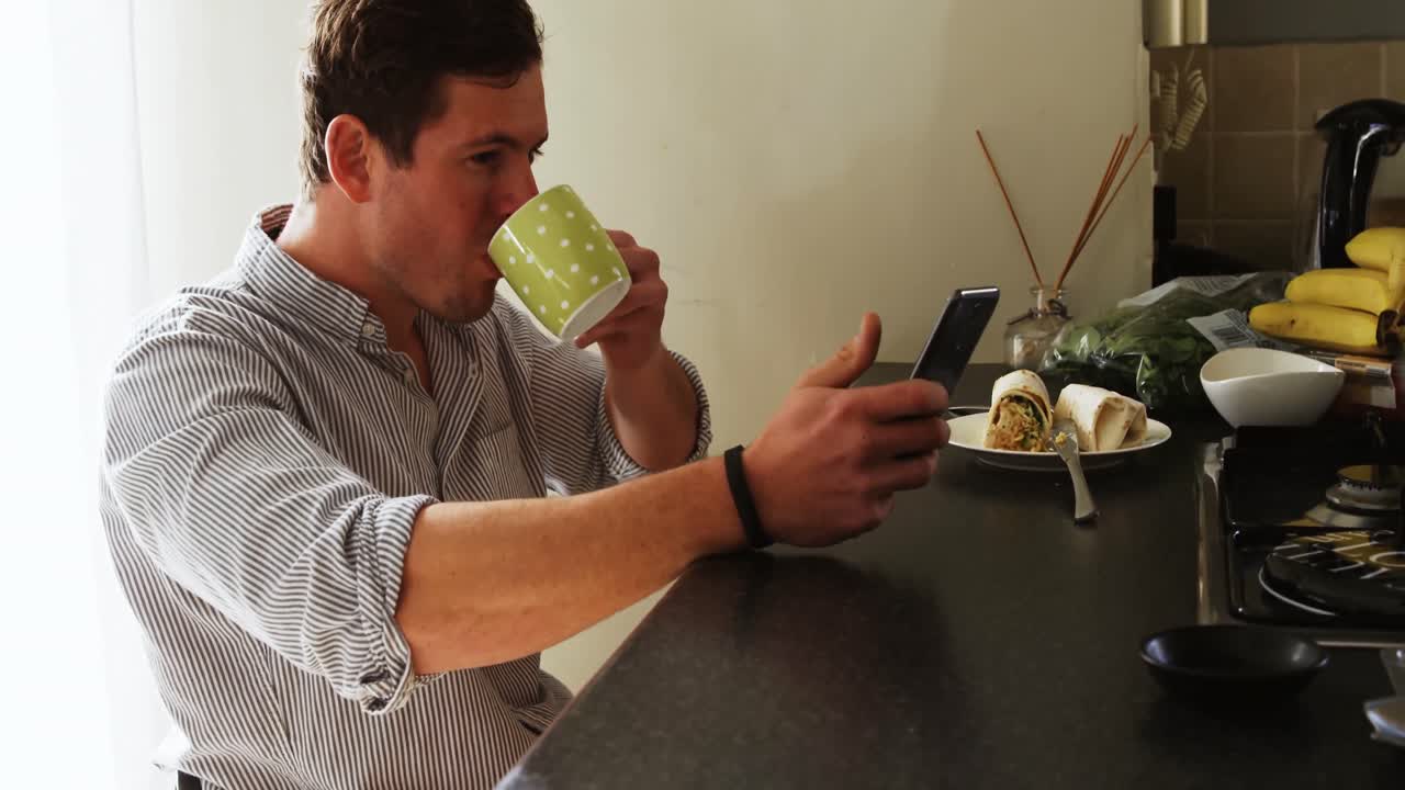 hombre discapacitado tomando café mientras usa teléfono móvil 4k