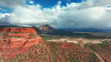 blue cloudy sky over red rock mountains in sedona, arizona - aerial drone shot