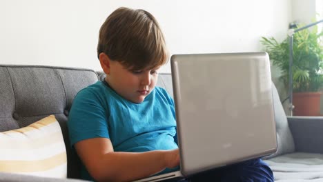 Boy-using-laptop-in-living-room-4k