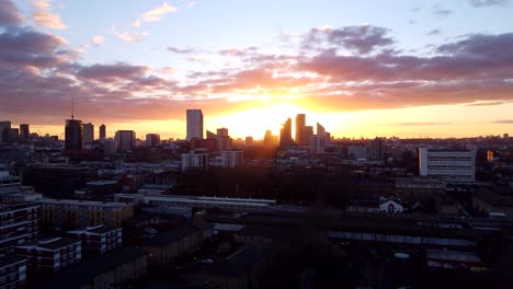 long and slow drone shot city skyline silhouetted at sunset in england