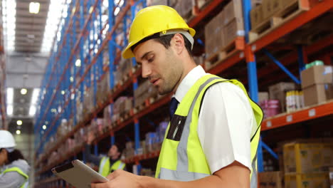 Warehouse-worker-using-his-tablet