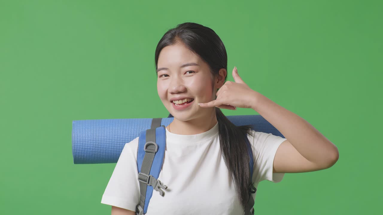 배 을 들고 있는 여자 가 전화 로 몸짓 을 하고 있다