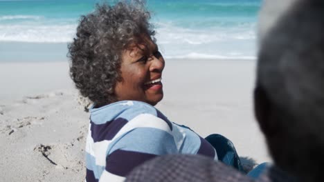 una pareja de alto nivel mirándose en la playa.
