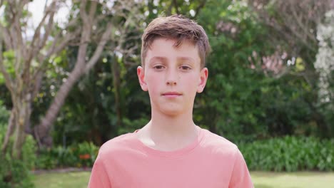 portrait of happy caucasian boy in garden