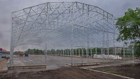 Static-shot-of-metal-frame-of-a-huge-godown-under-construction-in-timelapse-on-a-cloudy-day