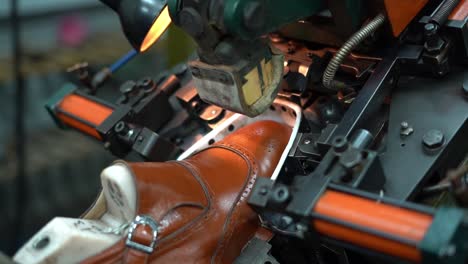 a craftsman handmade a shoe by a machine, close up shot, insert shot