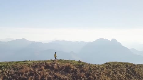 a men walks on a huge mountain ridge