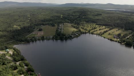 Lush-Green-Meadow-And-Mountain-Hills-Of-Mount-Pinacle-With-The-Calm-Lake-In-Coaticook,-Quebec,-Canada