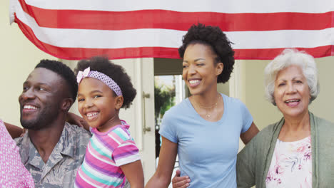 african american male soldier embracing his smiling family over american flag