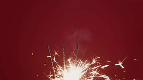 4k. chispas brillantes que queman la luz de navidad sobre un fondo rojo.