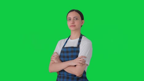 retrato de una ama de casa india de pie con las manos cruzadas pantalla verde