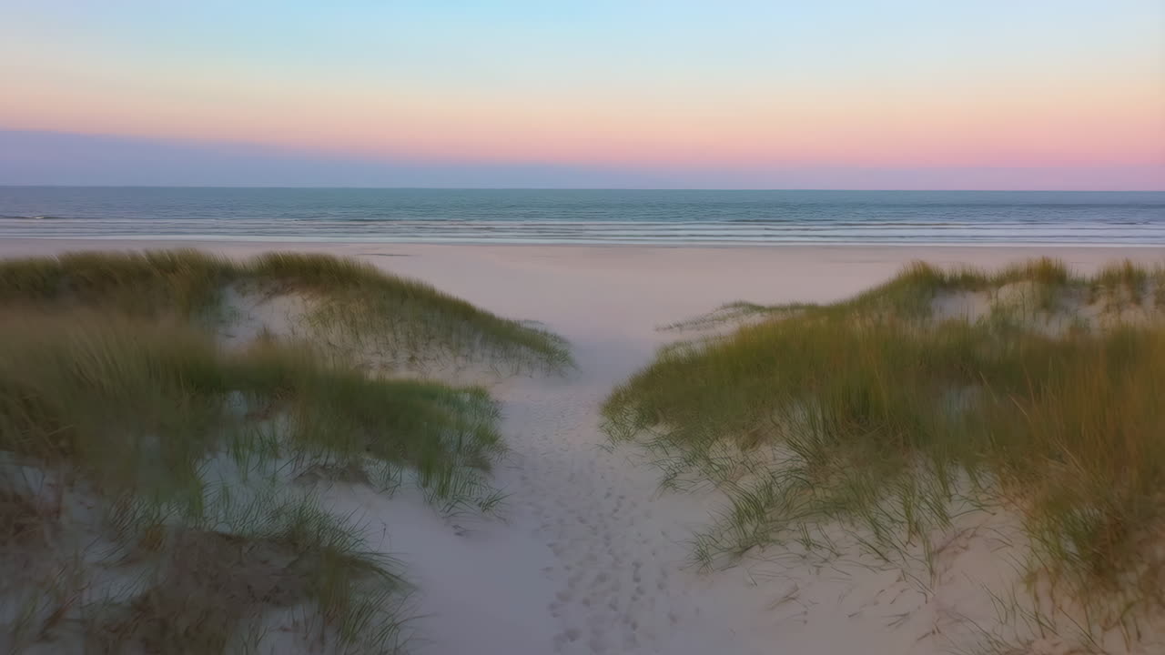 Path Through Sand Dunes Leading to a Serene Beach at Sunset