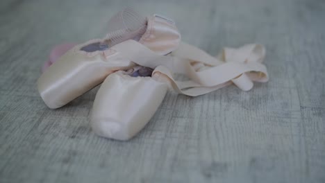 close-up of ballet pointe shoes on wooden surface