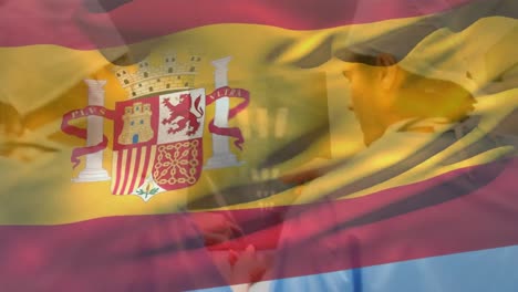 Animation-of-spain-flag,-diverse-surgeons-discussing-x-rays-while-walking-towards-operation-room