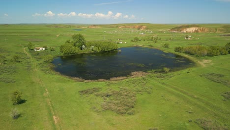 Pond-And-Green-Spring-Fields-In-Rural-Landscape---Aerial-Shot