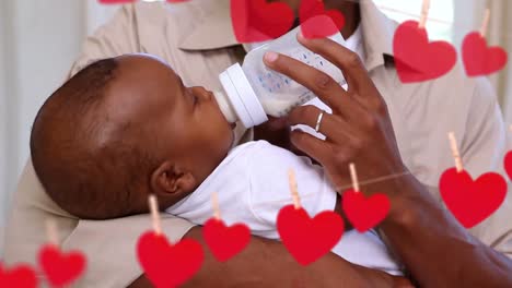 Animation-of-falling-hearts-over-happy-african-american-dad-with-baby