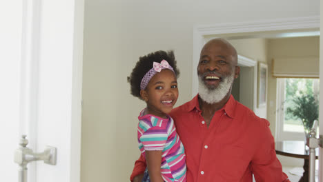 Retrato-De-Un-Feliz-Abuelo-Afroamericano-Llevando-A-Su-Nieta-Saludando