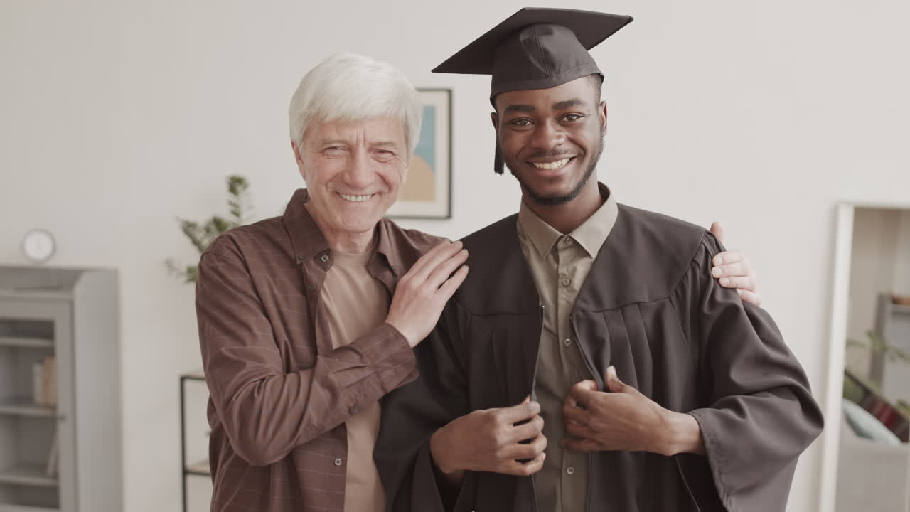 African-American Graduate and His Father on Online Graduation Ceremony