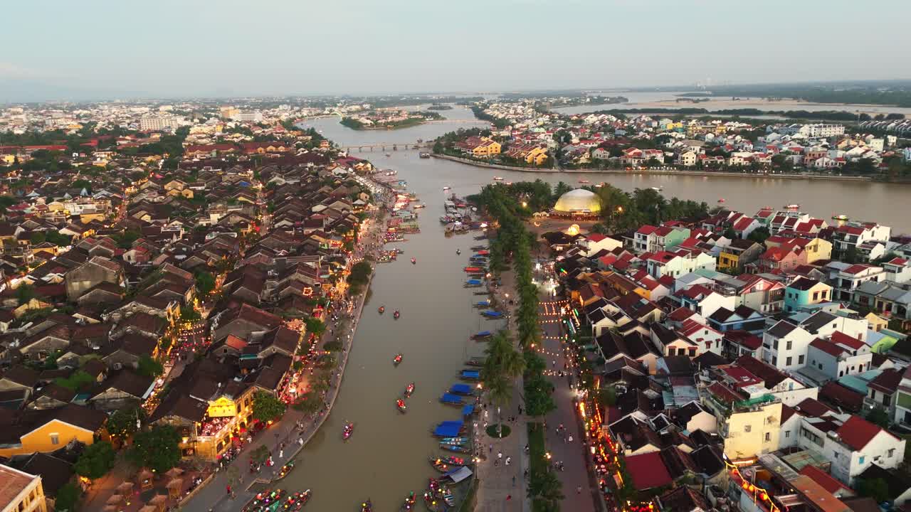 Toàn cảnh trên không tuyệt đẹp của Hội An, Việt Nam, lúc hoàng hôn, nổi bật với dòng sông uốn lượn cắt qua khu phố cổ hướng về đường chân trời mờ sương