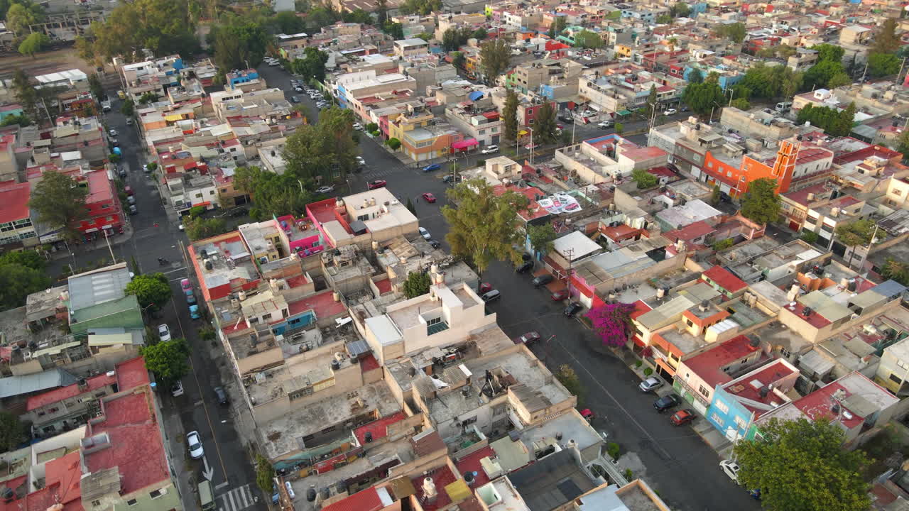 Sobrevoo aéreo de edifícios residenciais no bairro Salvador Diaz com carros circulando no tráfego rodoviário