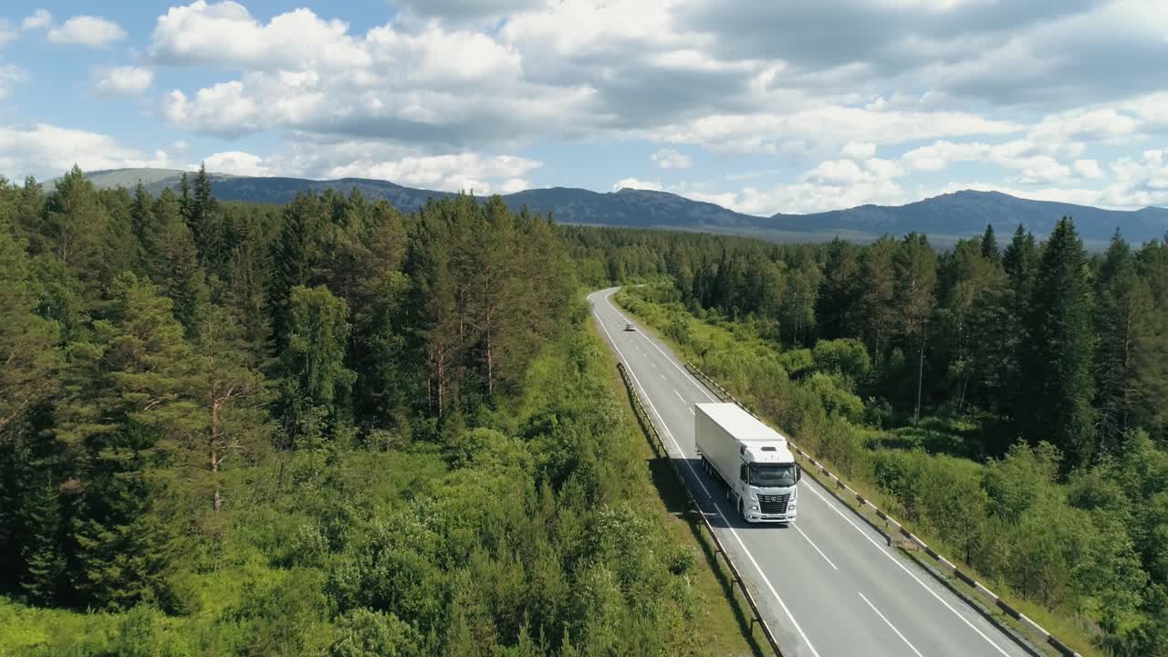 Lastbil på motorvej gennem skovlandskab