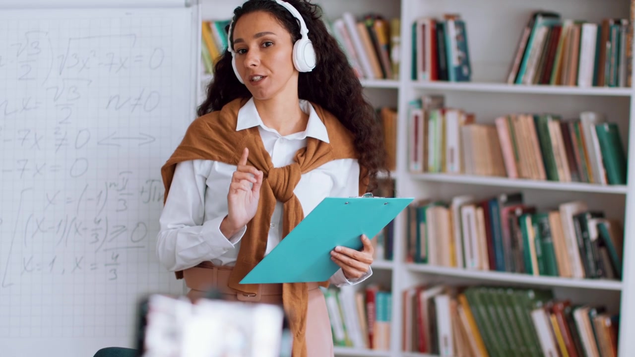 Insegnante donna che tiene una lezione online in biblioteca