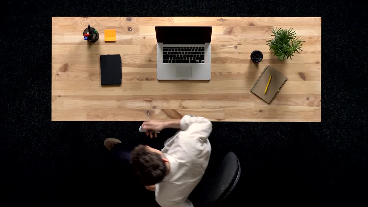Young man is working on laptop and leaving in daytime, work concept, office concept, communication concept, top shot