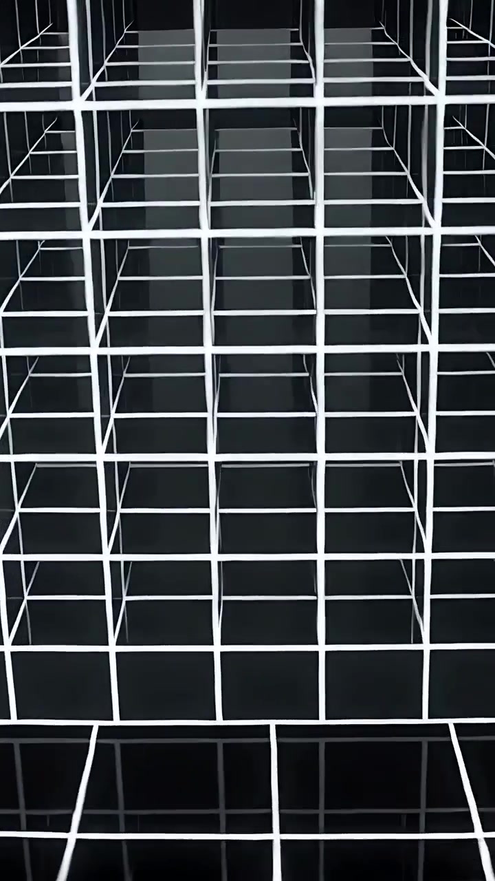 Video verticale: Telecamera che scorre oltre un prisma a griglia bianca su un pavimento nero, rivelando vuoti oscuri.