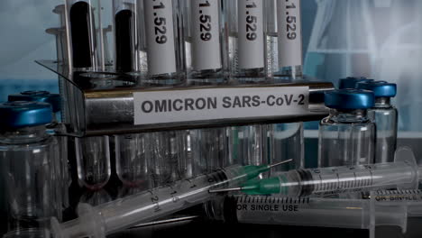 close up dolly shot of medical equipment labelled with omicron sars-cov-2 the new strain of covid 19, tracking back as glass test tubes are placed in a laboratory rack