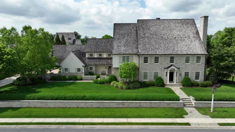 aerial lateral shot of 18th century style homes with steep-pitched cedar roofs and copper gutters and downspouts