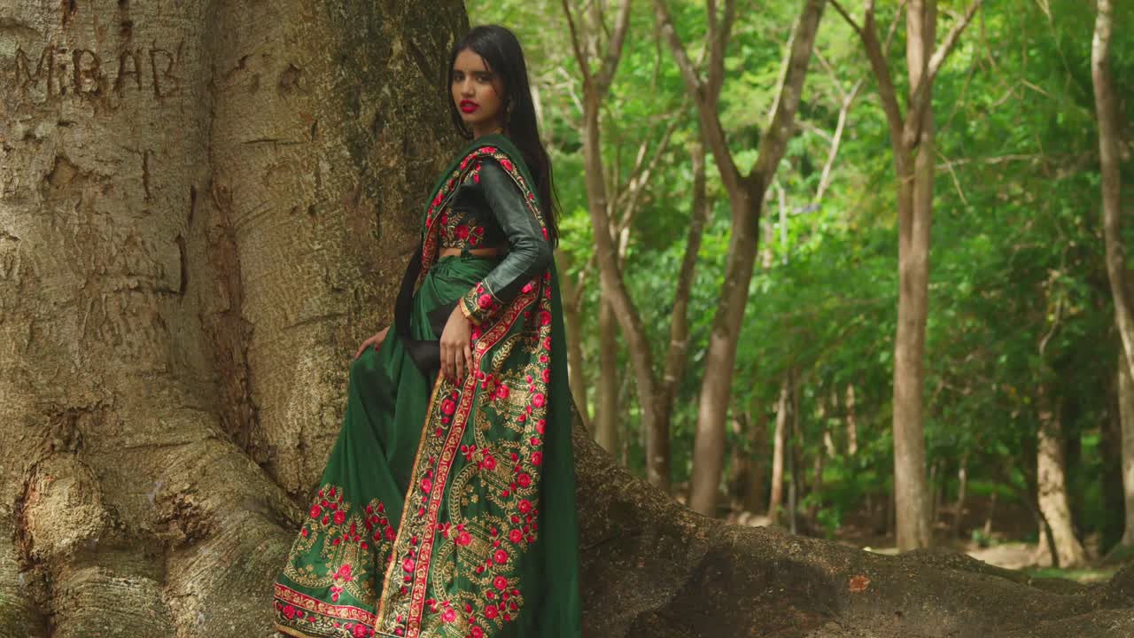 Uma jovem em traje tradicional indiano desfruta de um dia em um parque tropical no Caribe
