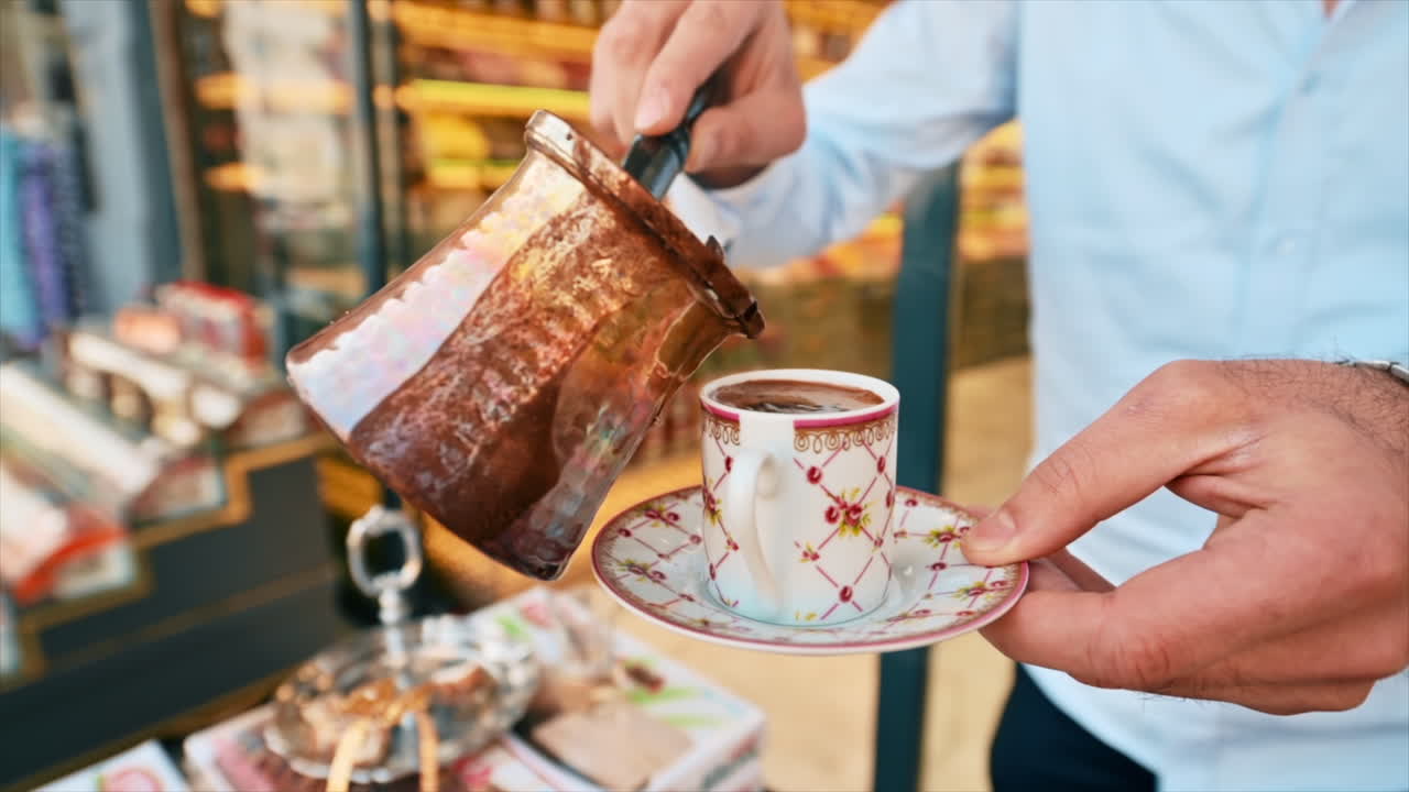 Nærbilde av en barista som heller kaffe i en tradisjonell tyrkisk kopp i Istanbul, Tyrkia. Sakte film