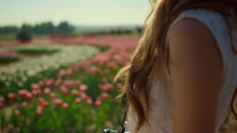 silhouette of unknown woman enjoying spring sun light in blooming flower garden.
