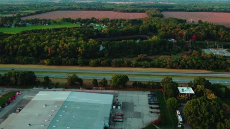 Aerial-wide-shot-of-Semi-trucks-on-highway-during-sunset