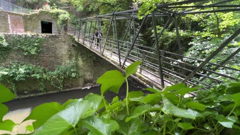 steel walkway over a river goyt, new mills with two people crossing slowly to the other side