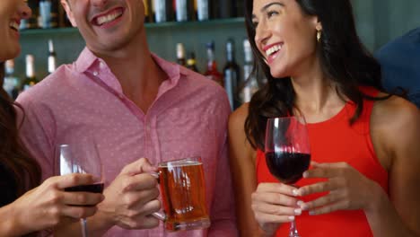 portrait of friends talking and holding drinks