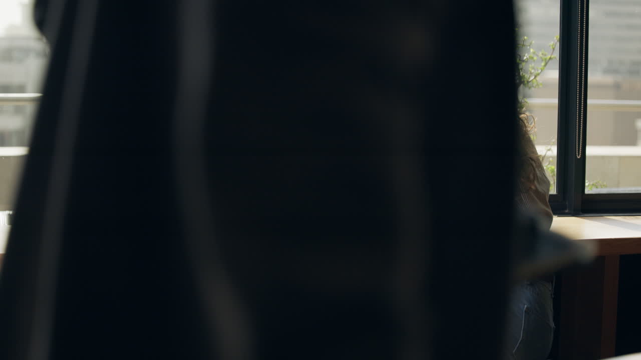 Two women collaborating on a project using a laptop in an office