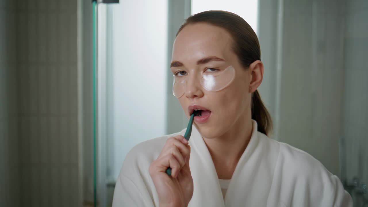 Closeup girl brushing teeth home. Pretty girl doing morning routine in bathroom
