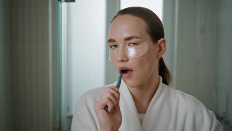 closeup girl brushing teeth home. pretty girl doing morning routine in bathroom