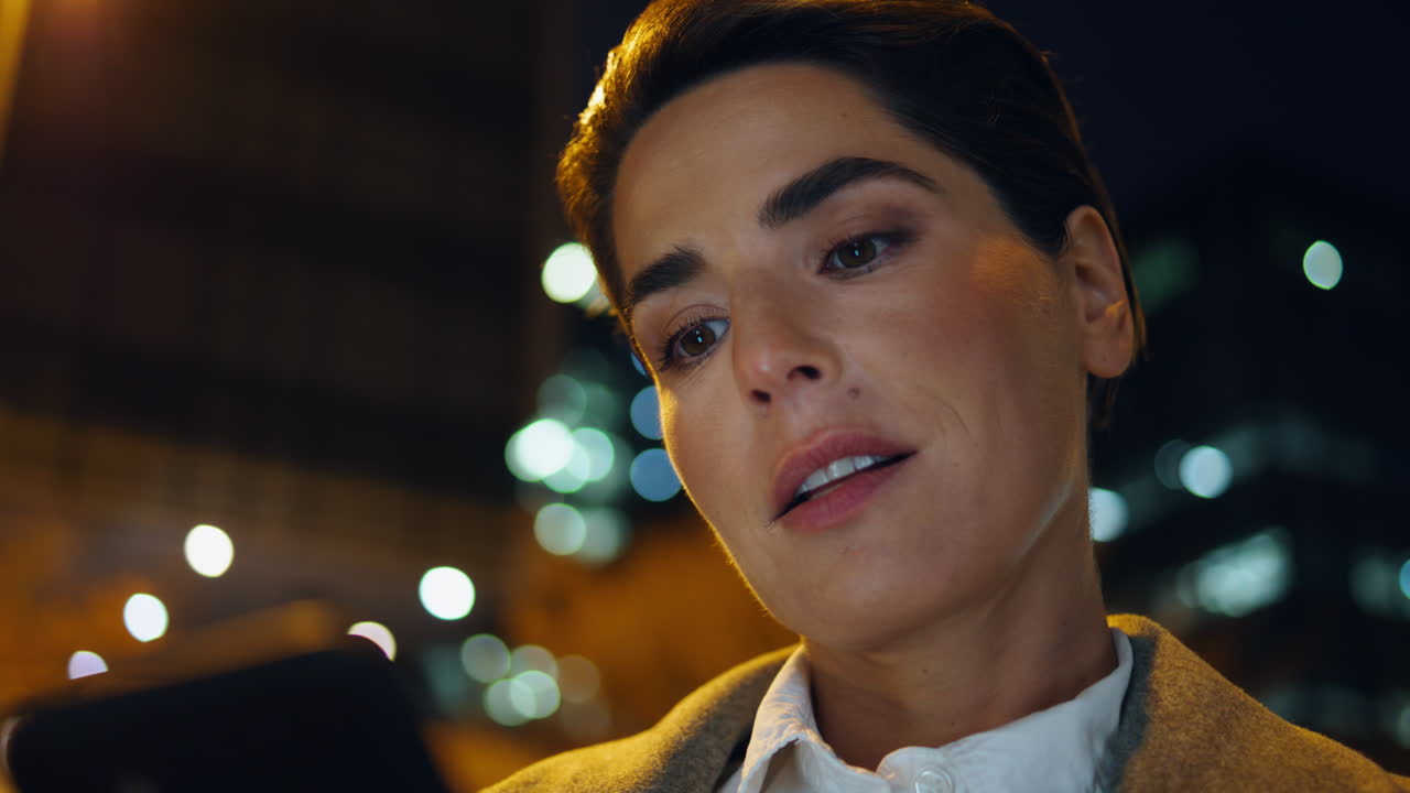 밤에 도시에서 스마트폰을 찾는 클로즈업 여성. 아름다운 사업가 여성 문자 메시지