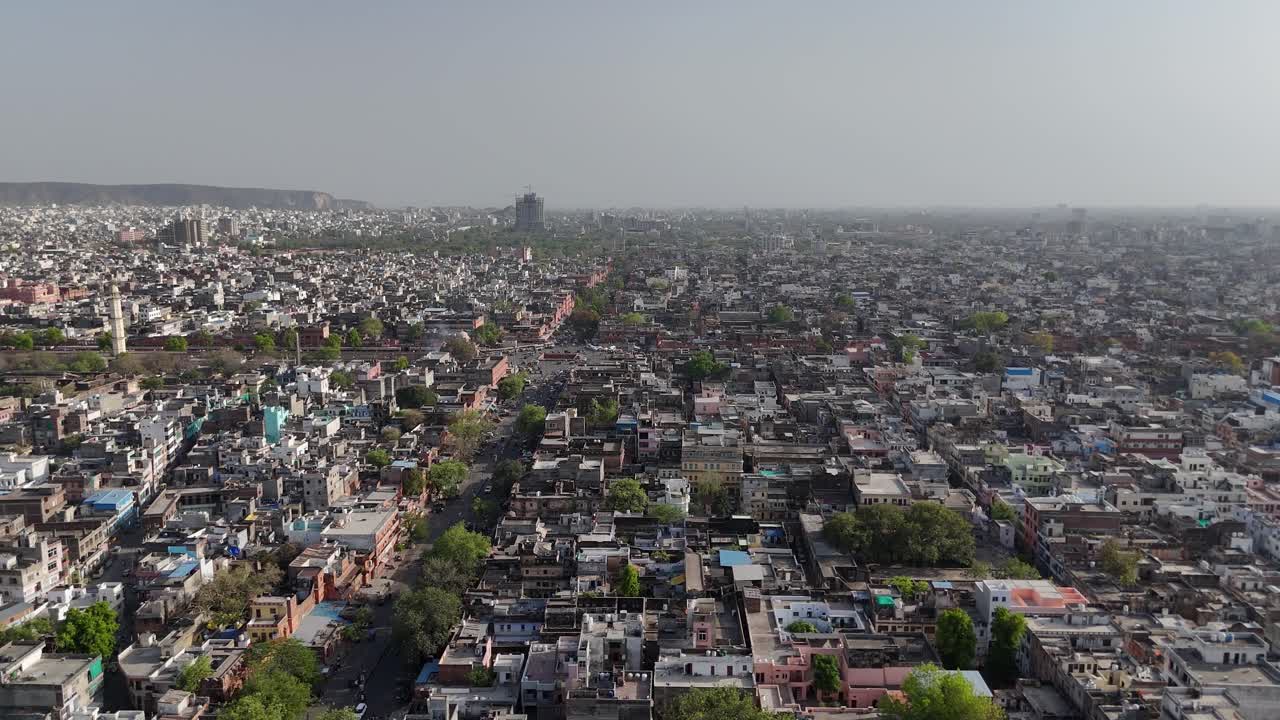 Aerial shot capturing the striking contrast between rugged hills and dense city life.
